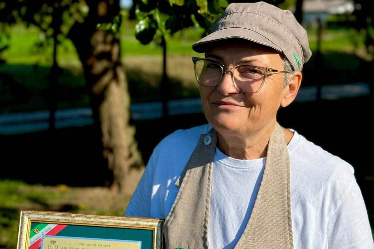 Una socia della fattoria con il premio per il formaggio fresco e un cremosello